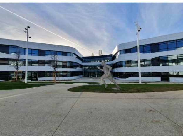 Dans un ensemble paysager, des plateaux de bureau