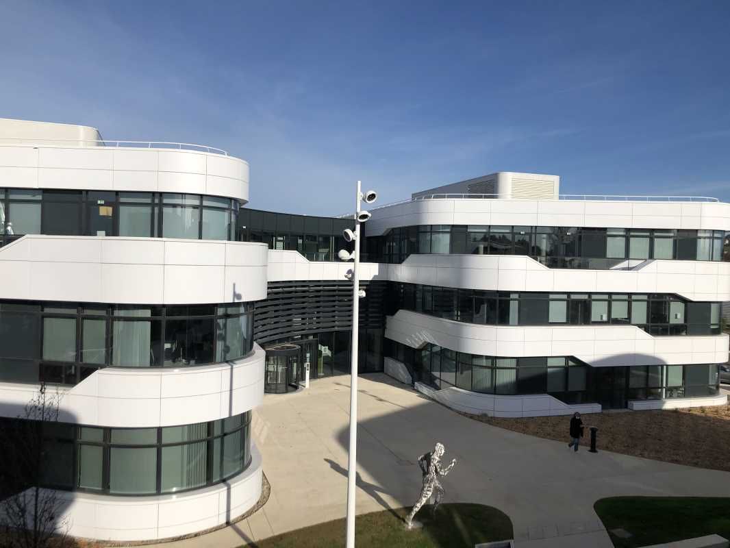 Dans un ensemble paysager, des plateaux de bureau