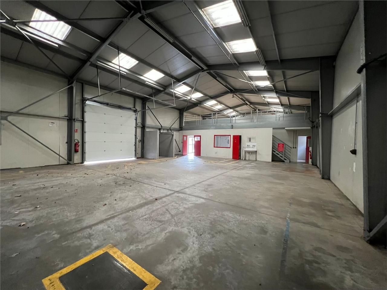 Sur un grand terrain clos et enrobé, en façade de