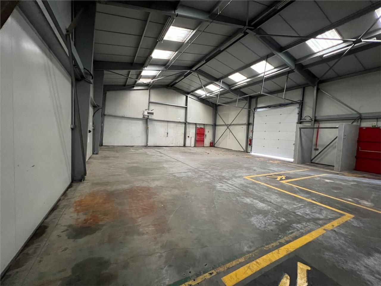 Sur un grand terrain clos et enrobé, en façade de