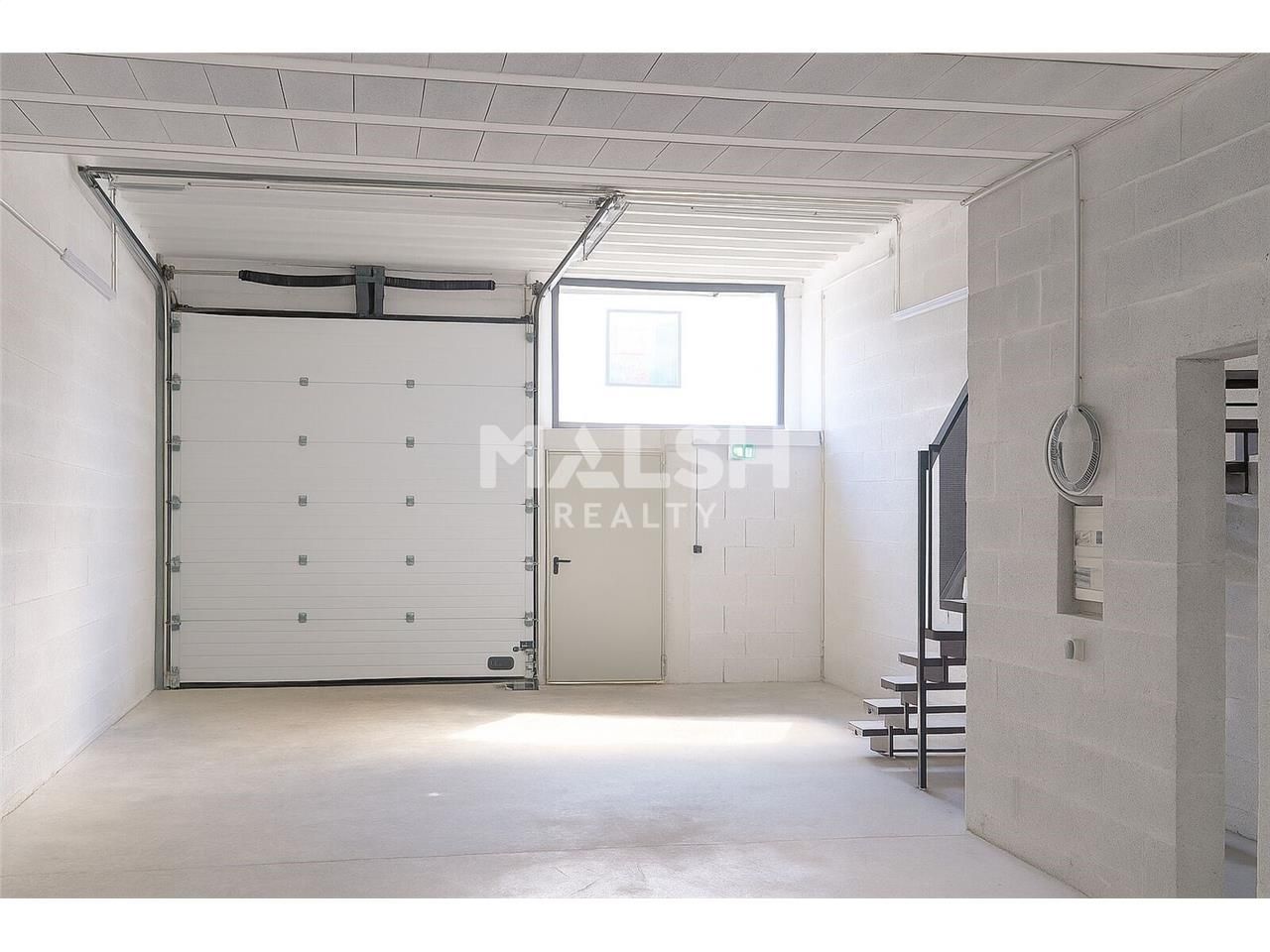 Dans un parc d'activités sécurisé avec portail et